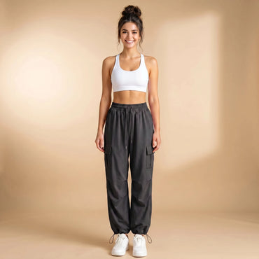 Woman in deep grey high-waist cargo joggers with flap thigh pockets, cuffed loose-fit pants, front view