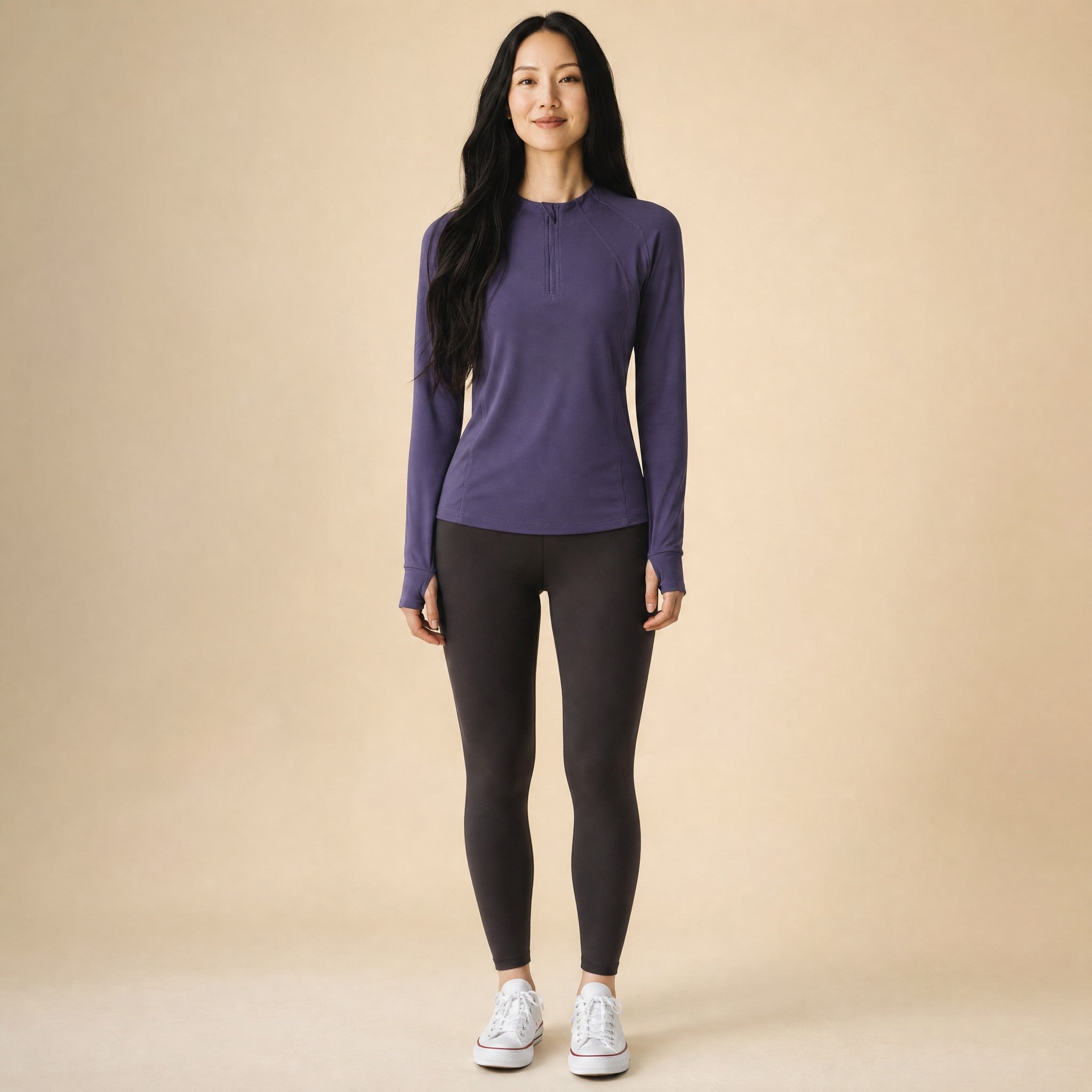 Woman wearing a deep purple quarter-zip long-sleeve running top, front view
