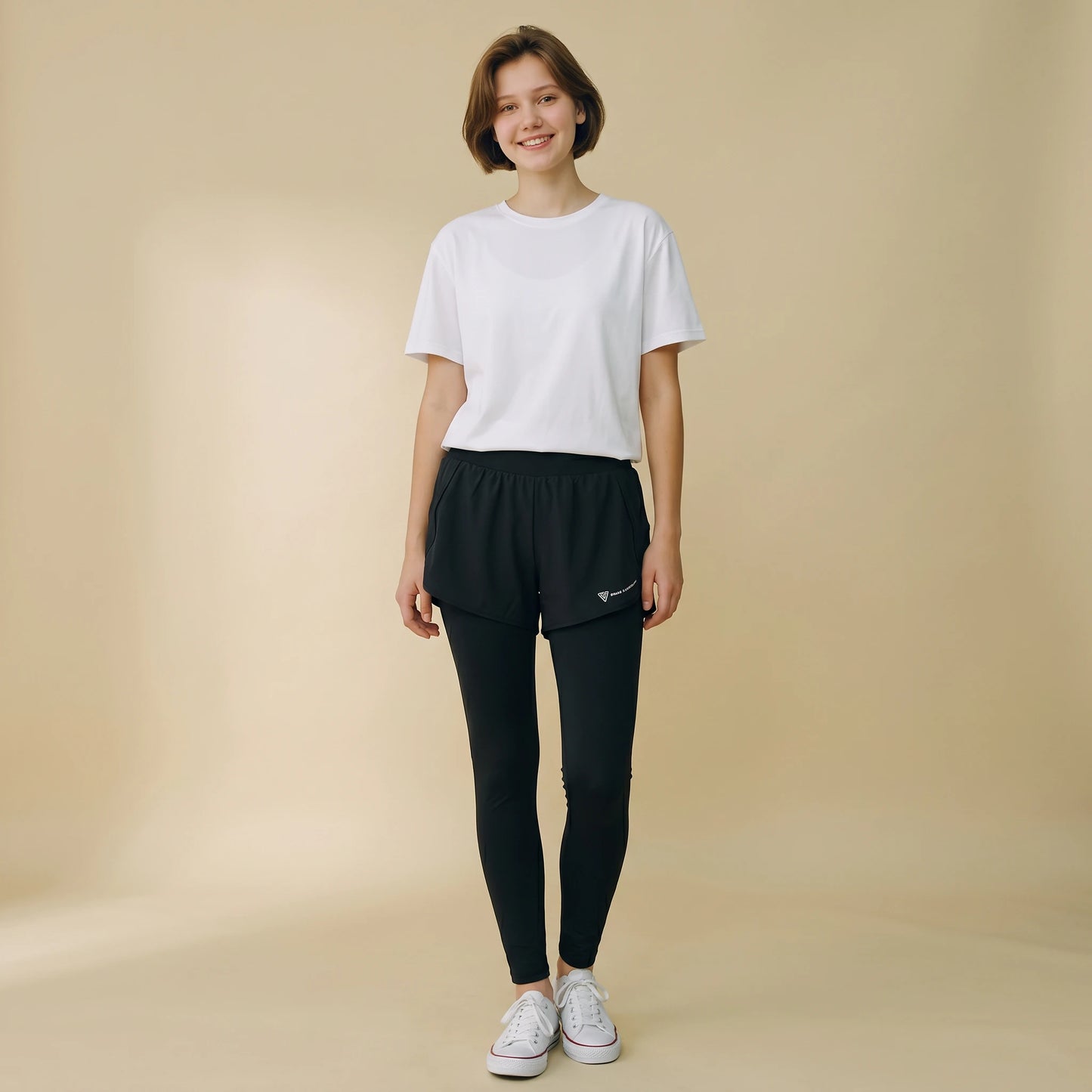 Woman in black 2-in-1 high-waist leggings with built-in overlay shorts, full-length yoga pants, front view