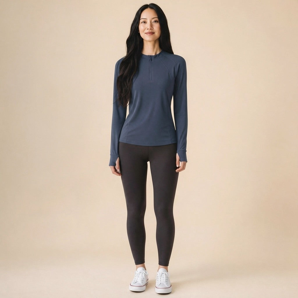 Woman wearing a navy blue quarter-zip long-sleeve running top, front view