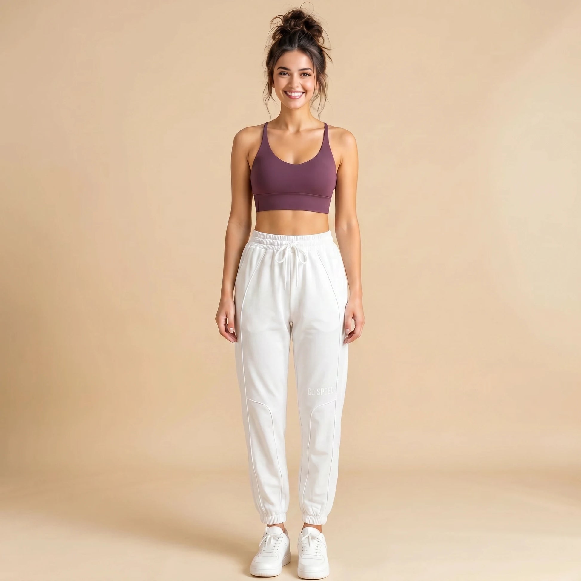 Woman in white high-waist loose-fit joggers, tapered cuffed drawstring sweatpants, front view