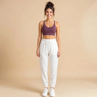 Woman in white high-waist loose-fit joggers, tapered cuffed drawstring sweatpants, front view