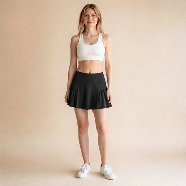High-waist athletic skort in black, ruffle-pleated A-line tennis and golf skirt with built-in shorts, front view