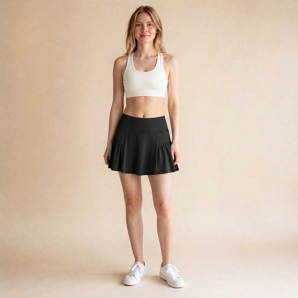 High-waist athletic skort in black, ruffle-pleated A-line tennis and golf skirt with built-in shorts, front view