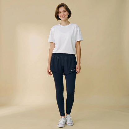 Woman in navy blue 2-in-1 high-waist leggings with built-in overlay shorts, full-length yoga pants, front view